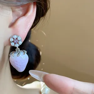Detailed close-up of a sweet resin strawberry earring with floral stud and pearls
