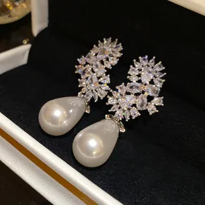 Primer plano detallado de elegantes pendientes de perlas con racimos de circonitas brillantes