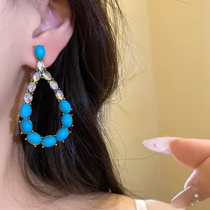 Primo piano dettagliato di orecchini a goccia vintage con pietre blu e cristalli brillanti