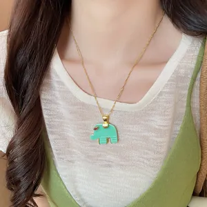 Detailed shot of a green resin elephant pendant necklace worn by a female model