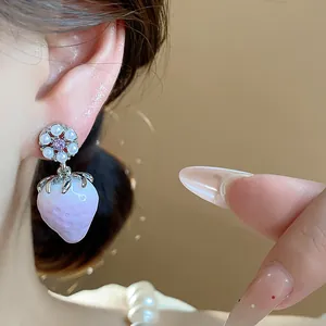 Close-up of sweet light purple resin strawberry earrings with pearl flower detail.