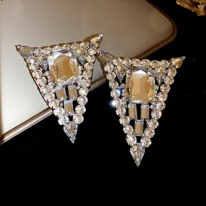 Detailed macro shot of luxury crystal encrusted triangle stud earrings in silver