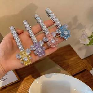 Gros plan de barrettes à cheveux avec zircone étincelante et ours en résine colorés.