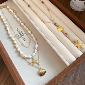 Detailed shot of conch and starfish pendant necklaces displayed in a jewelry tray
