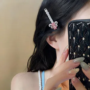 Vue détaillée d'une pince à cheveux élégante avec ours rose et nœud en zircone sur un modèle
