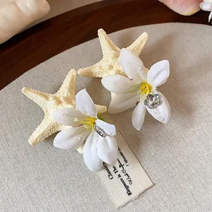 Detailed view of exquisite starfish and flower hair clips on a textured background.