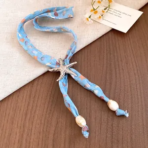 Macro view of ocean-themed scarf necklace with silver starfish charm and shell bead accents