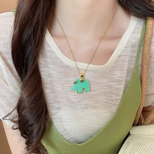 Close-up detail of a green resin elephant pendant necklace worn by a female model.