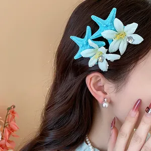 Close-up of elegant starfish and flower hair clip worn on model for beach vacation.