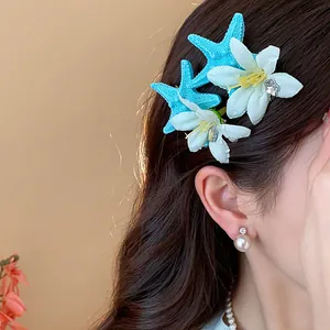 Close-up of beach style hair clip with blue starfish and white flowers on hair