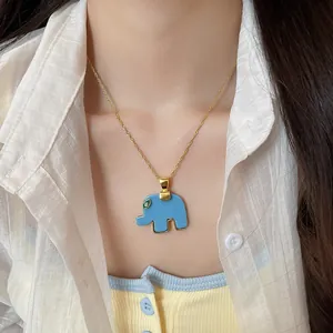 Close-up of blue resin elephant pendant necklace with green rhinestone eye on model