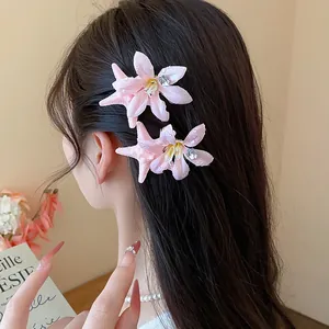 Detailed view of pink starfish flower hair clips styled on long dark hair accessory