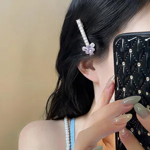 Gros plan d'une élégante pince à cheveux papillon en zircon avec un petit ours en résine.