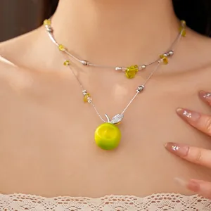 Double-layered beaded necklace with green resin apple pendant and sparkling zircons