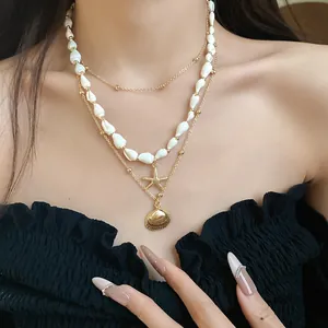 Detail view of a three-layer necklace set with conch, starfish, and shell charms on a model