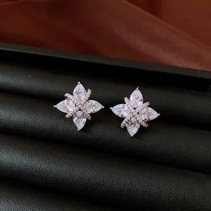 Close-up of star-shaped zircon ear clips in a black textured jewelry box