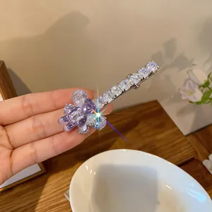 Détail d'une barrette à cheveux ours en résine violette avec zircons sur base argentée.