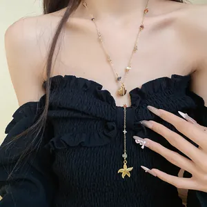 Detailed close-up view of a beach-style starfish and shell pendant necklace on a model