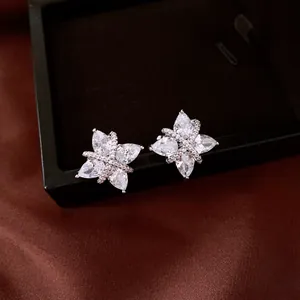 Macro view of sparkling zircon flower clip-on earrings presented in a black jewelry box
