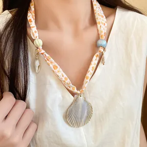 Close-up of ocean-style silk scarf necklace with real shells and beads for vacation wear