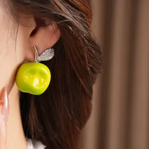 Detailed view of sweet green resin apple earring with sparkling zircon leaf detail
