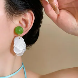 Detailansicht der eleganten koreanischen Ohrclips mit grünem Harz und weißen Quasten