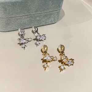 Detailed shot of gold and silver plated star earrings with sparkling cubic zirconia