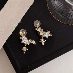 Detailed view of gold-plated star clip-on earrings with sparkling zircon stones.