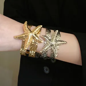 Bracciale rigido aperto a stella marina in metallo martellato nei colori oro e argento