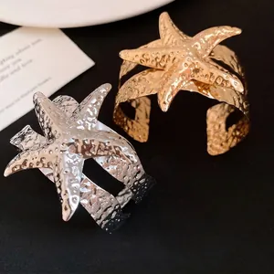 Bracciali aperti a forma di stella marina in metallo martellato, colori oro e argento