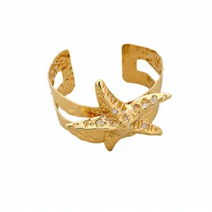 Bracciale rigido aperto a stella marina martellata dorata per donna elegante.