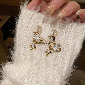 Close-up detail of 14k gold plated star shaped ear clips with sparkling zircon stones