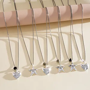 Vue détaillée des pendentifs cœur et étoile en argent avec texture et texte gravé