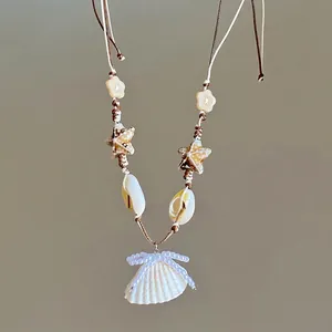 Detail view of beach style necklace featuring natural shells, starfish, and pearls.