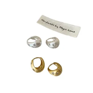 Créoles minimalistes brossées avec motif d'étoile en zircon en fini or et argent.