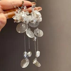 Detalle de pendientes de clip con borlas de perlas barrocas y conchas vintage francesas