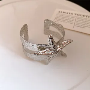 Dettaglio macro del bracciale rigido in metallo martellato con ciondolo stella