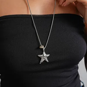 Gros plan d'un pendentif étoile argenté texturé avec gravure 'Promise me' chic