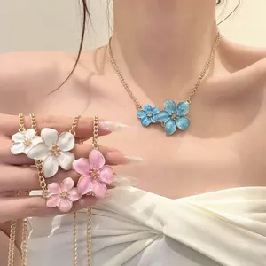Close-up detail of colorful enamel flower necklaces in blue, pink and white hues