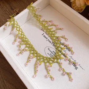 Close-up detail of a handmade beaded fringe necklace in lime green and pink beads