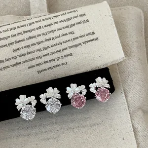 Vista dettagliata di orecchini a lobo floreali con cristalli rosa e trasparenti in argento.