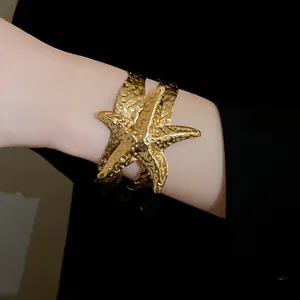 Primo piano dettagliato di un elegante bracciale a stella marina in metallo dorato.