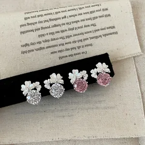 Primo piano di eleganti orecchini a fiore con cristalli scintillanti rosa e bianchi.