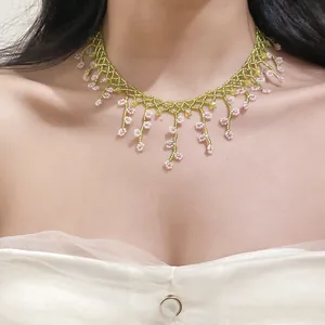 Detailed close-up of a handmade beaded lace choker with delicate pink flower fringes