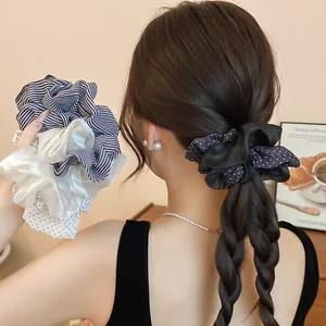 Detail view of elegant polka dot and striped fabric scrunchies worn on braided hair