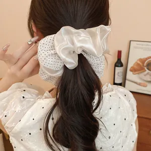 Detailed view of white double-layered polka dot scrunchie on a ponytail