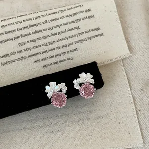 Primo piano di orecchini a lobo a fiore rosa con delicati petali bianchi e strass