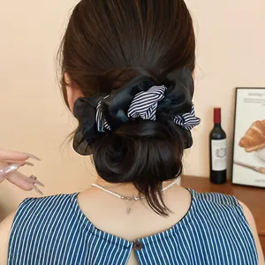 Detailed back view of a fashionable striped double-layer hair scrunchie in a low bun hairstyle