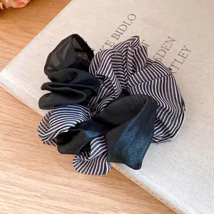 Close-up detail of black and white striped double-layer fabric hair scrunchie accessory