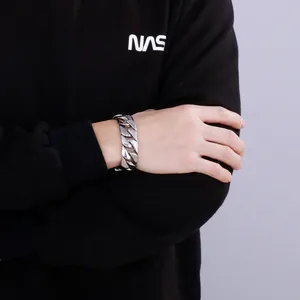 Men's chunky polished silver stainless steel Cuban link bracelet shown on model's wrist